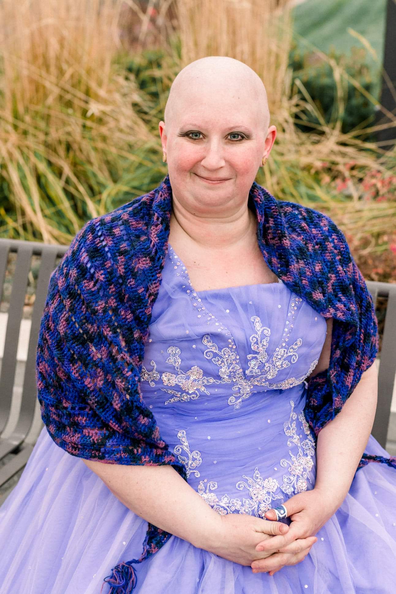 Cancer survivor picture sitting in a purple gown.